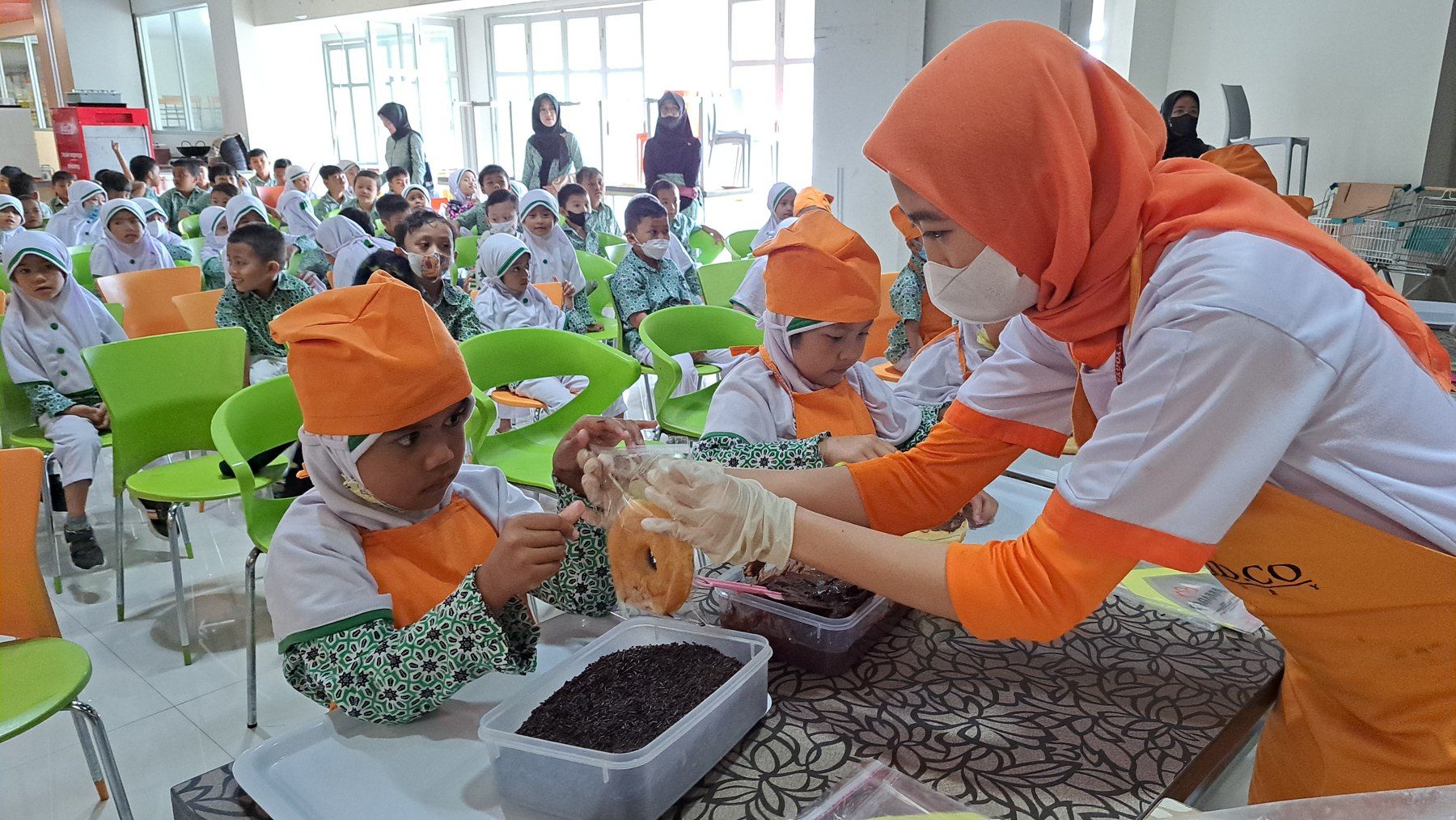 Pendidik mendampingi anak-anak dalam kegiatan membuat makanan.