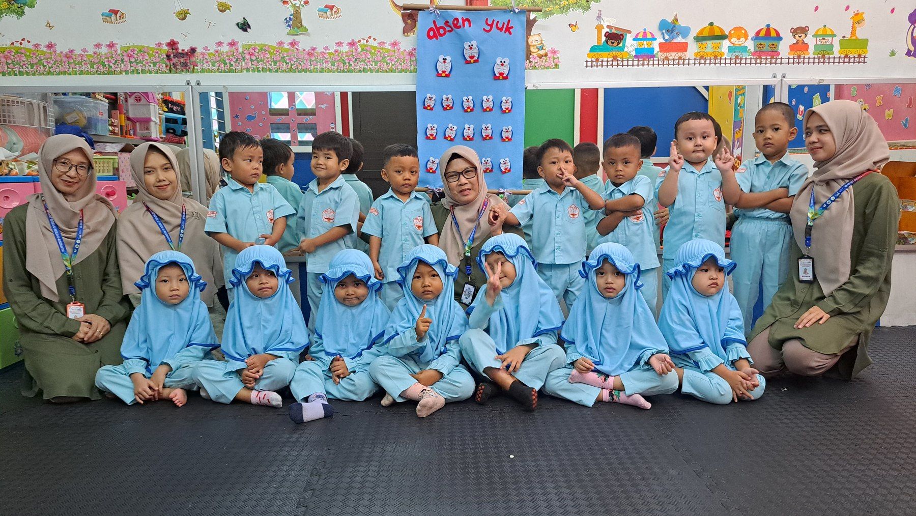 Anak-anak Kelompok Bermain bersama para pendidik di ruang kelas.