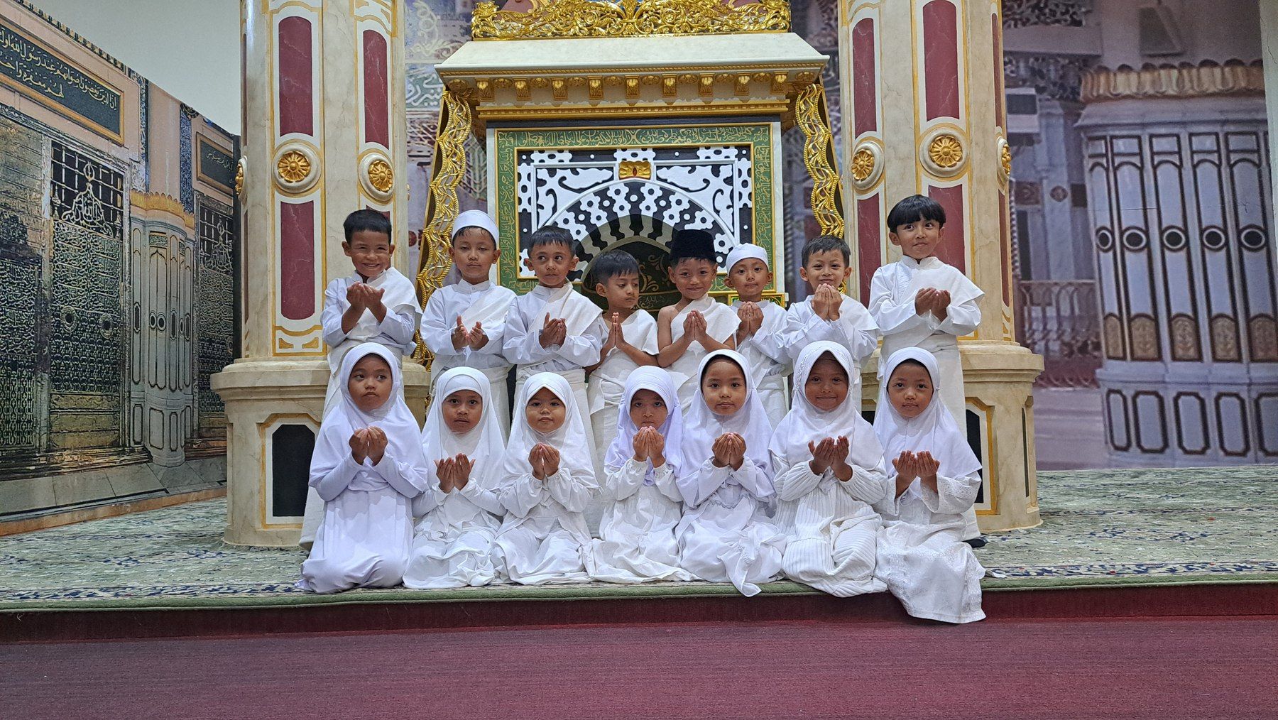 Anak-anak dan pendidik berfoto dalam kegiatan manasik.