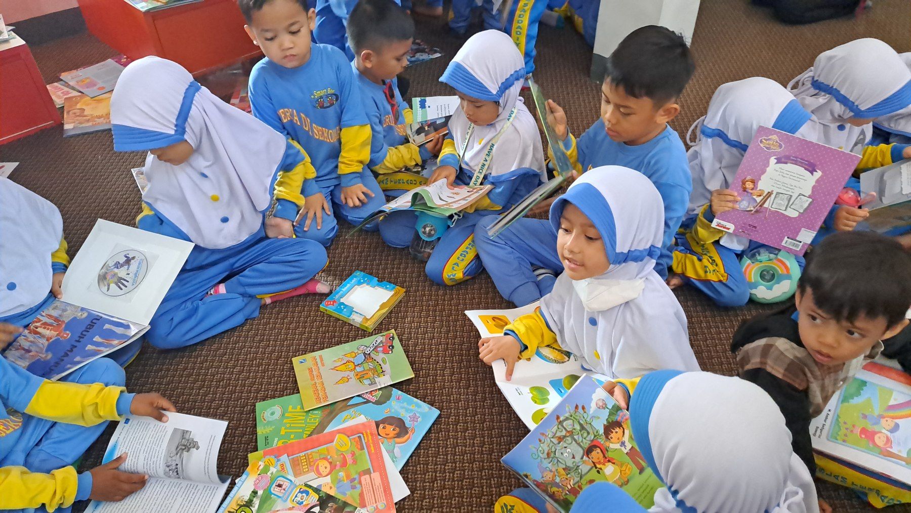 Anak-anak membuka buku bersama dalam kegiatan literasi.